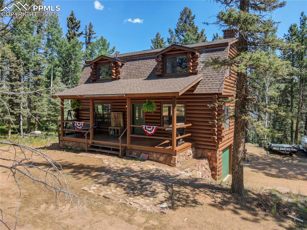 Log-style house with a garage and a porch