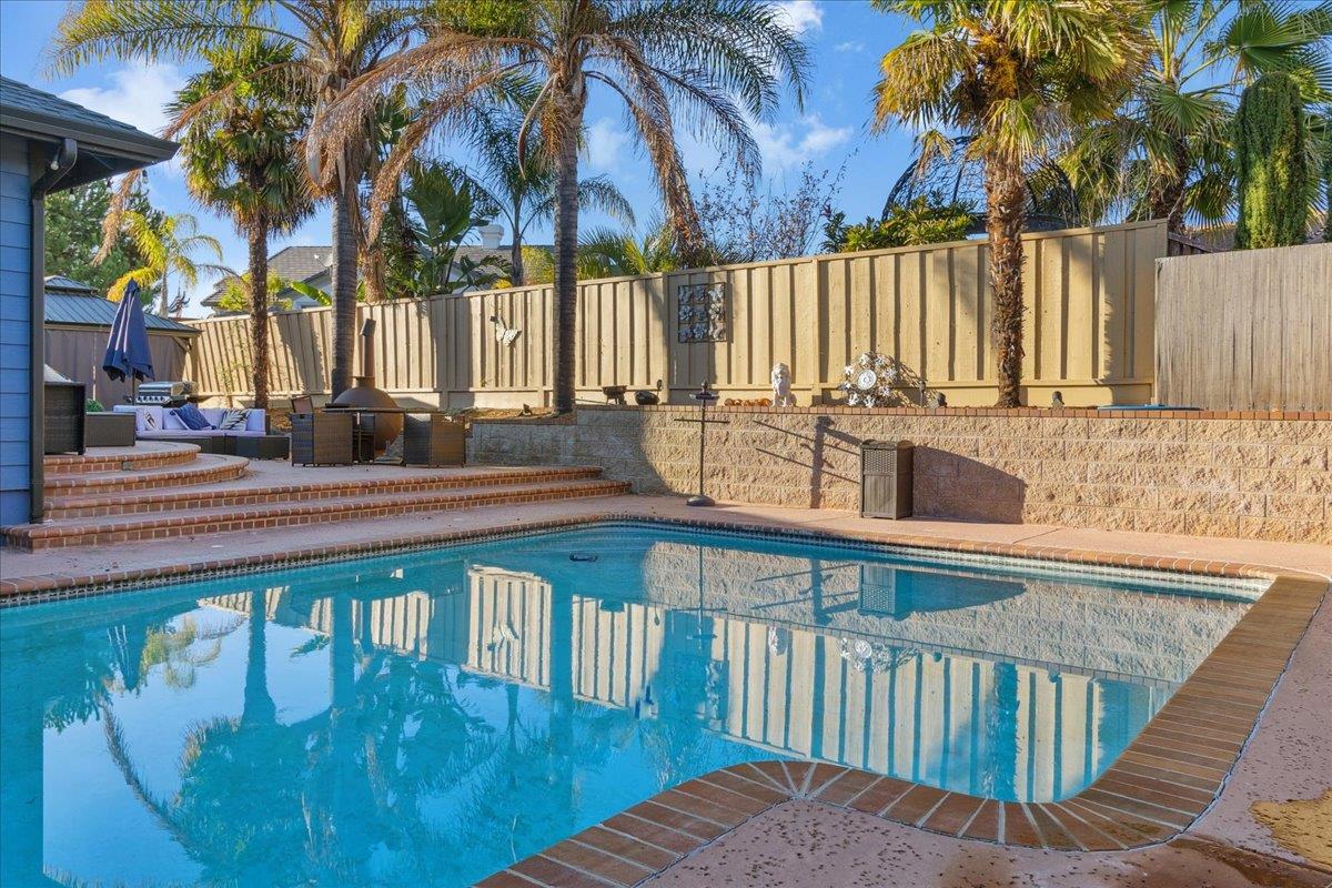 a view of a roof deck with couches and wooden fence