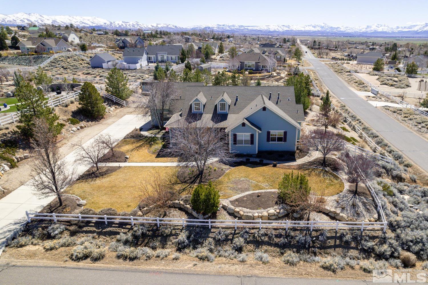 a view of a house with a yard and mountain view in back