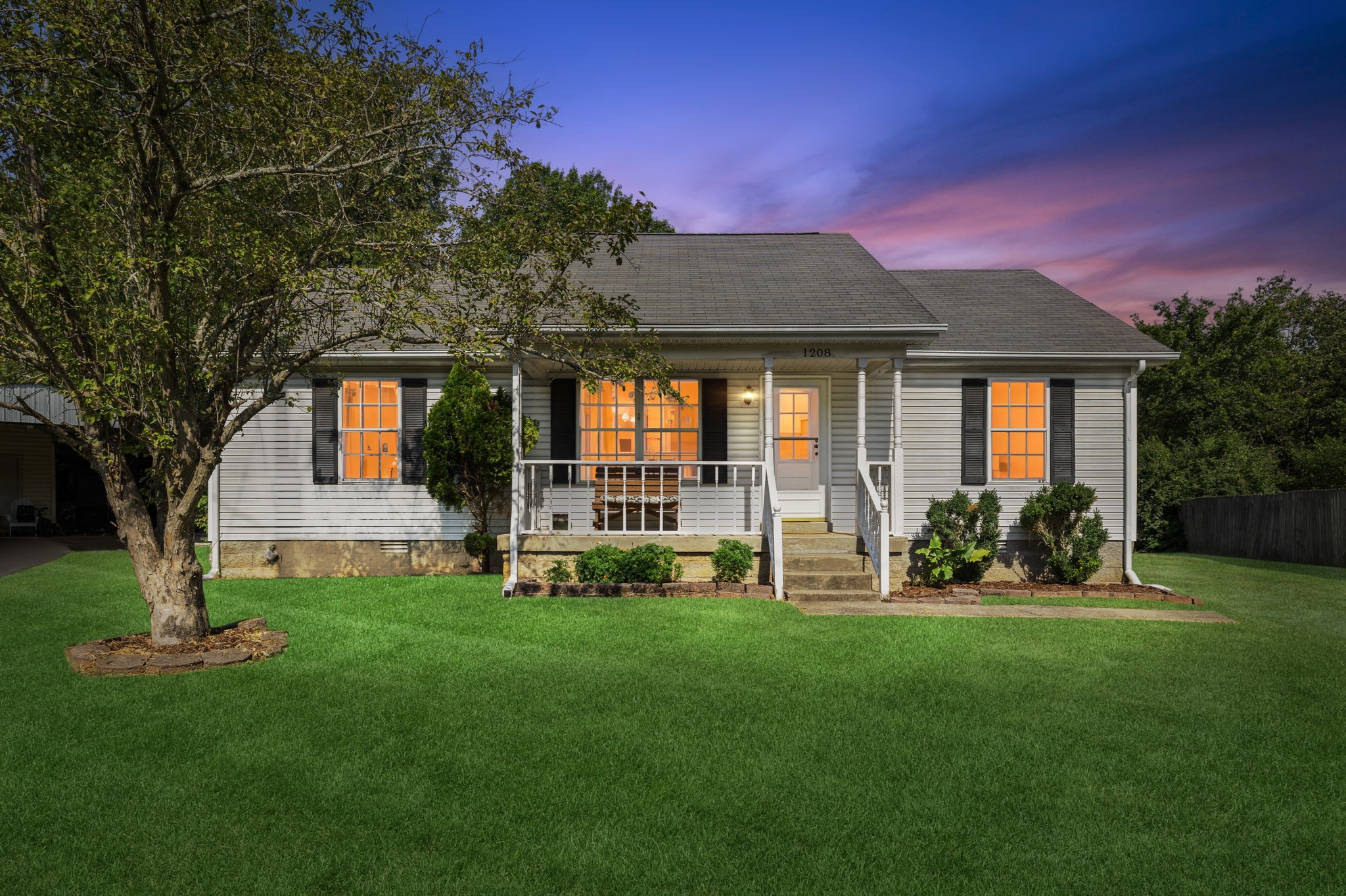 a front view of a house with a yard and green space