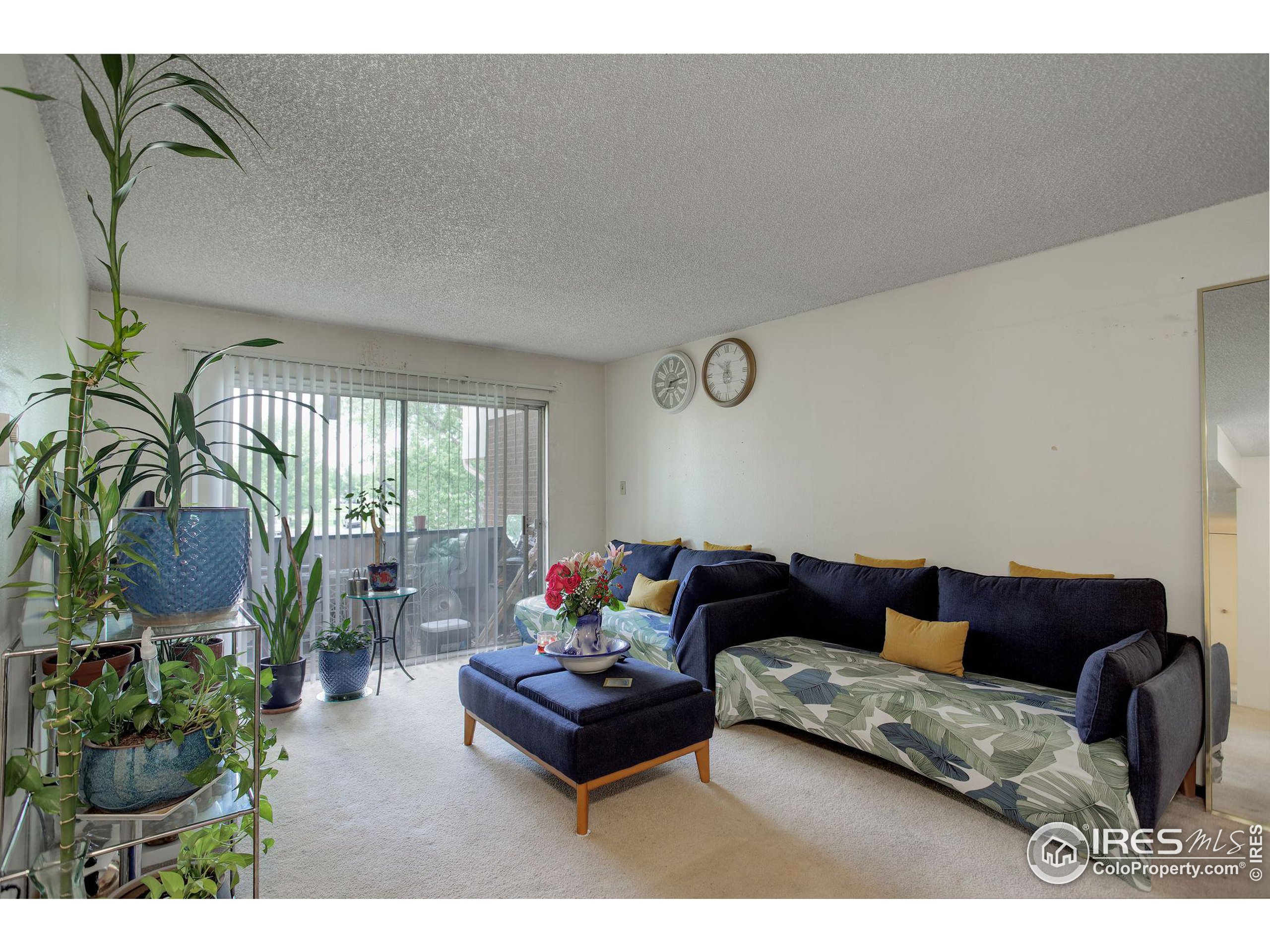 a living room with furniture and a floor to ceiling window