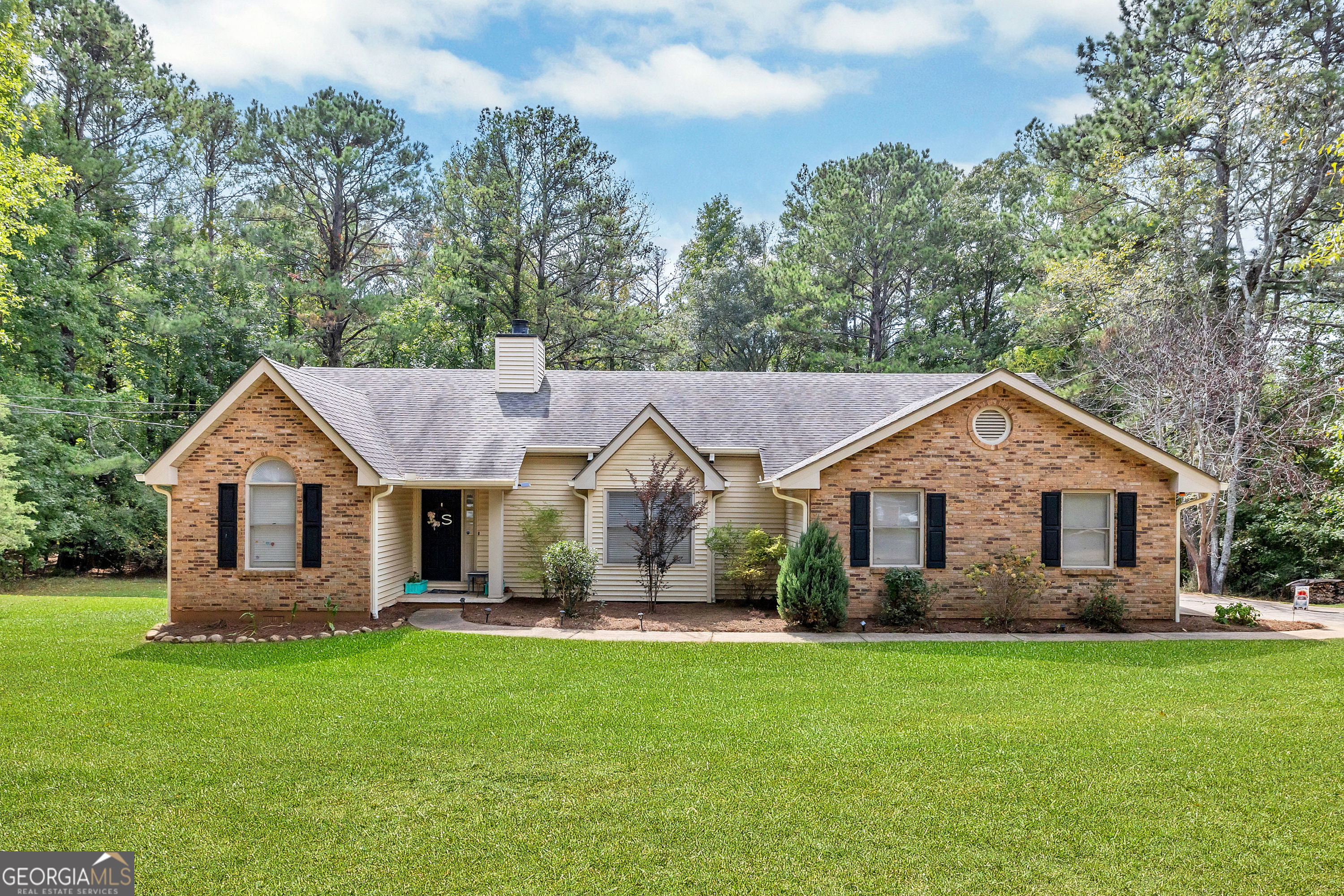 a front view of a house with a garden and yard