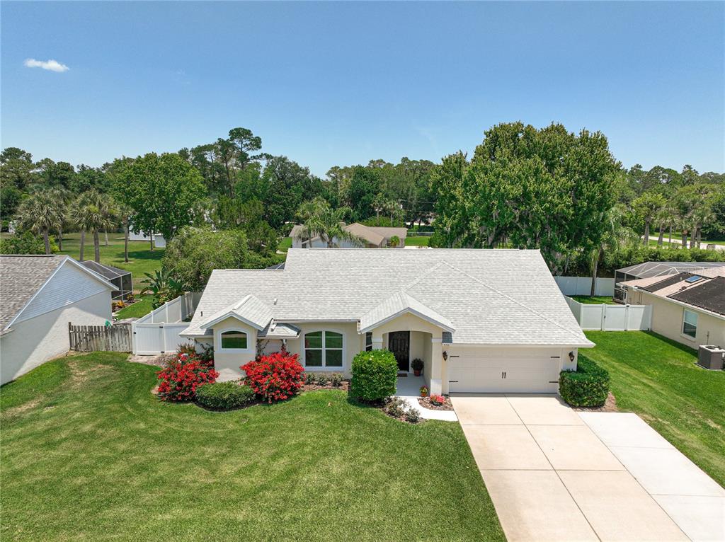 a aerial view of a house with yard and green space