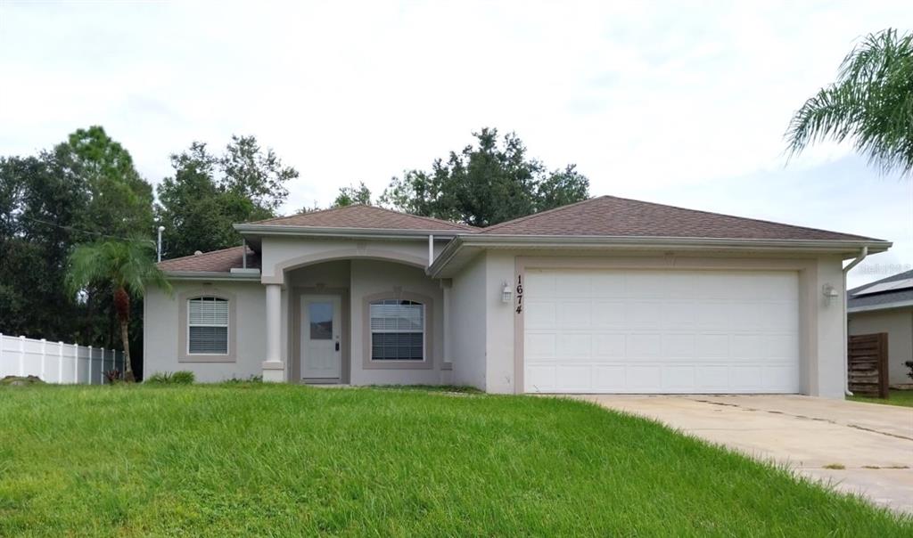 a front view of a house with a garden and yard