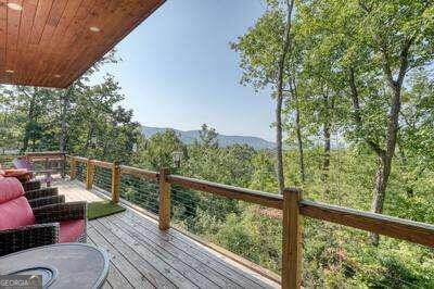 a view of a balcony with couches wooden floor and fence