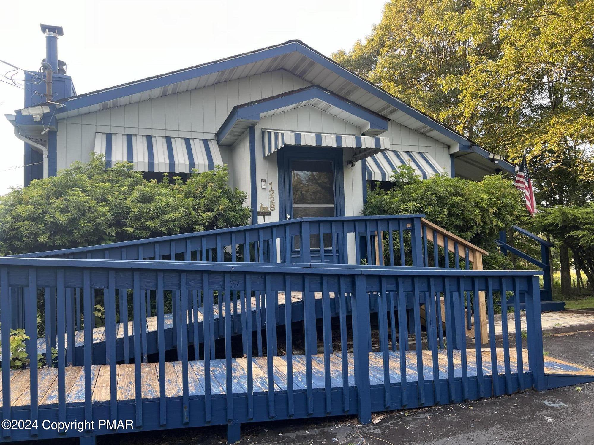 a view of wooden house with a small yard and wooden fence