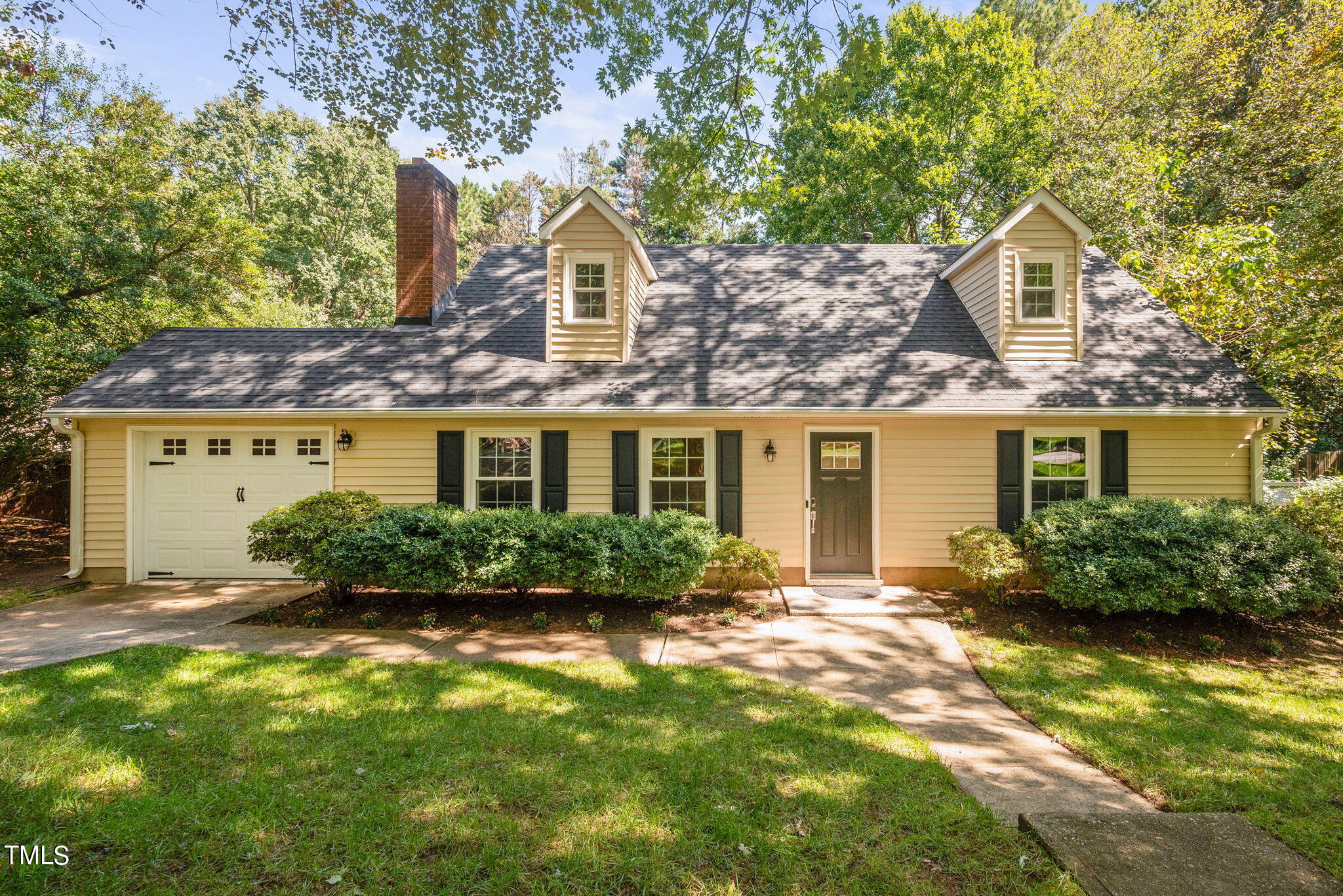 a front view of a house with a yard and potted plants