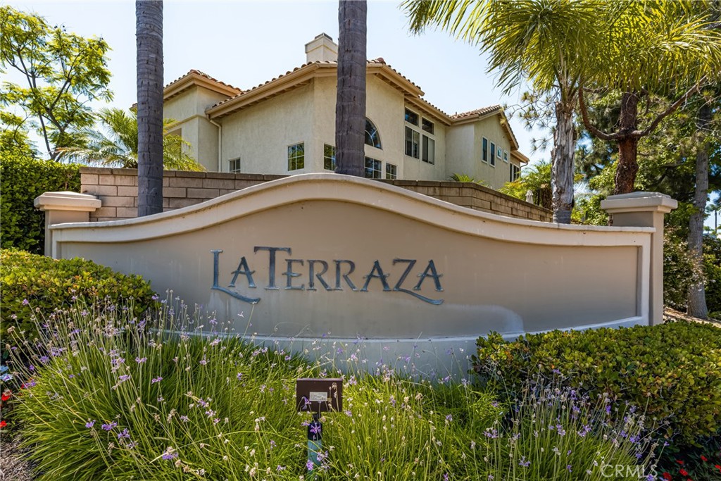 a front view of a house with a garden and signage