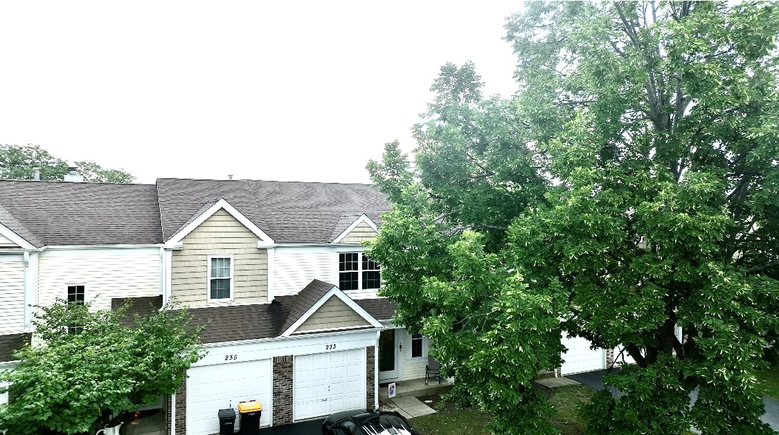 a view of house with a tree and a yard