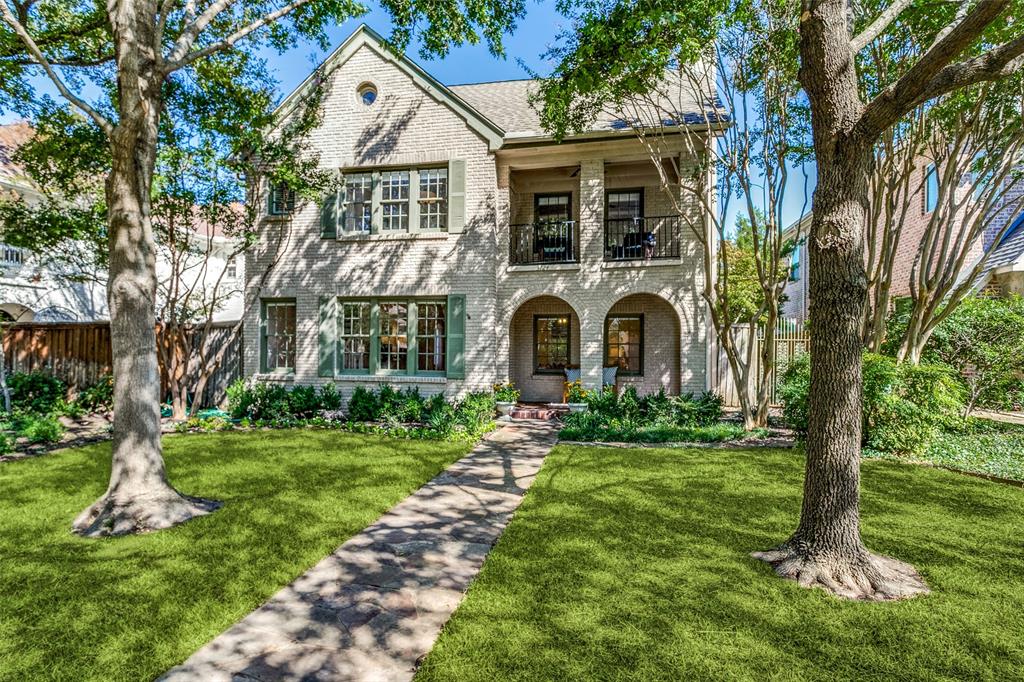 a front view of a house with a yard and trees