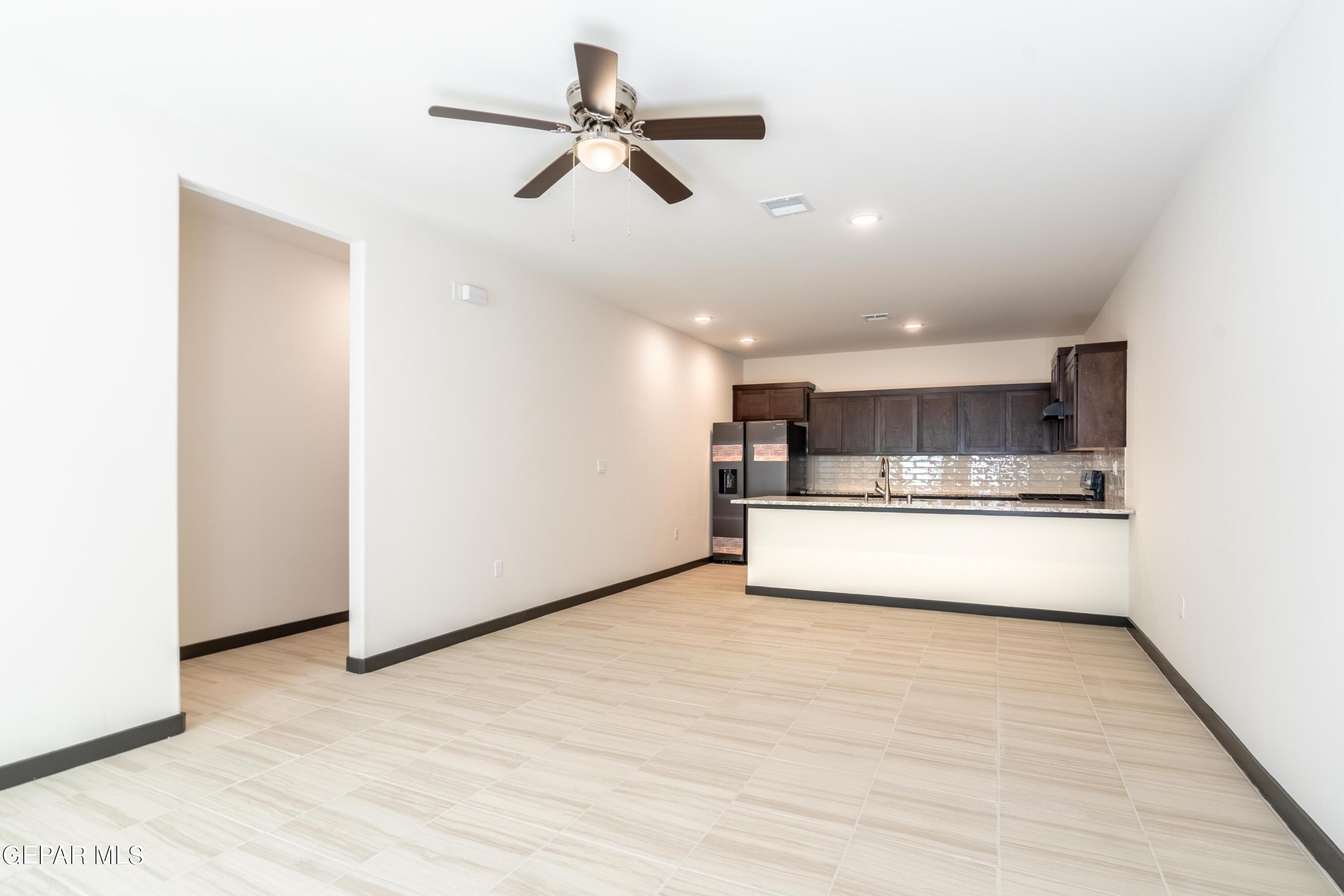 a view of an empty room with a ceiling fan