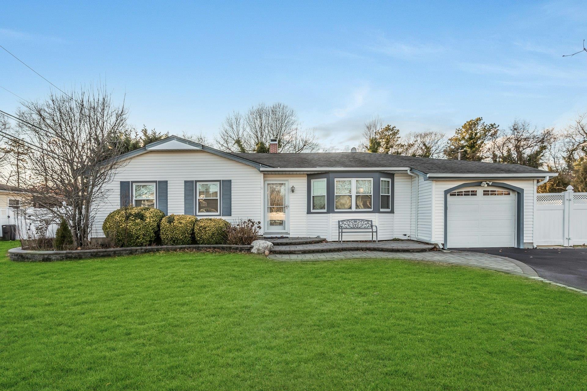 Ranch-style home with a front yard and a garage