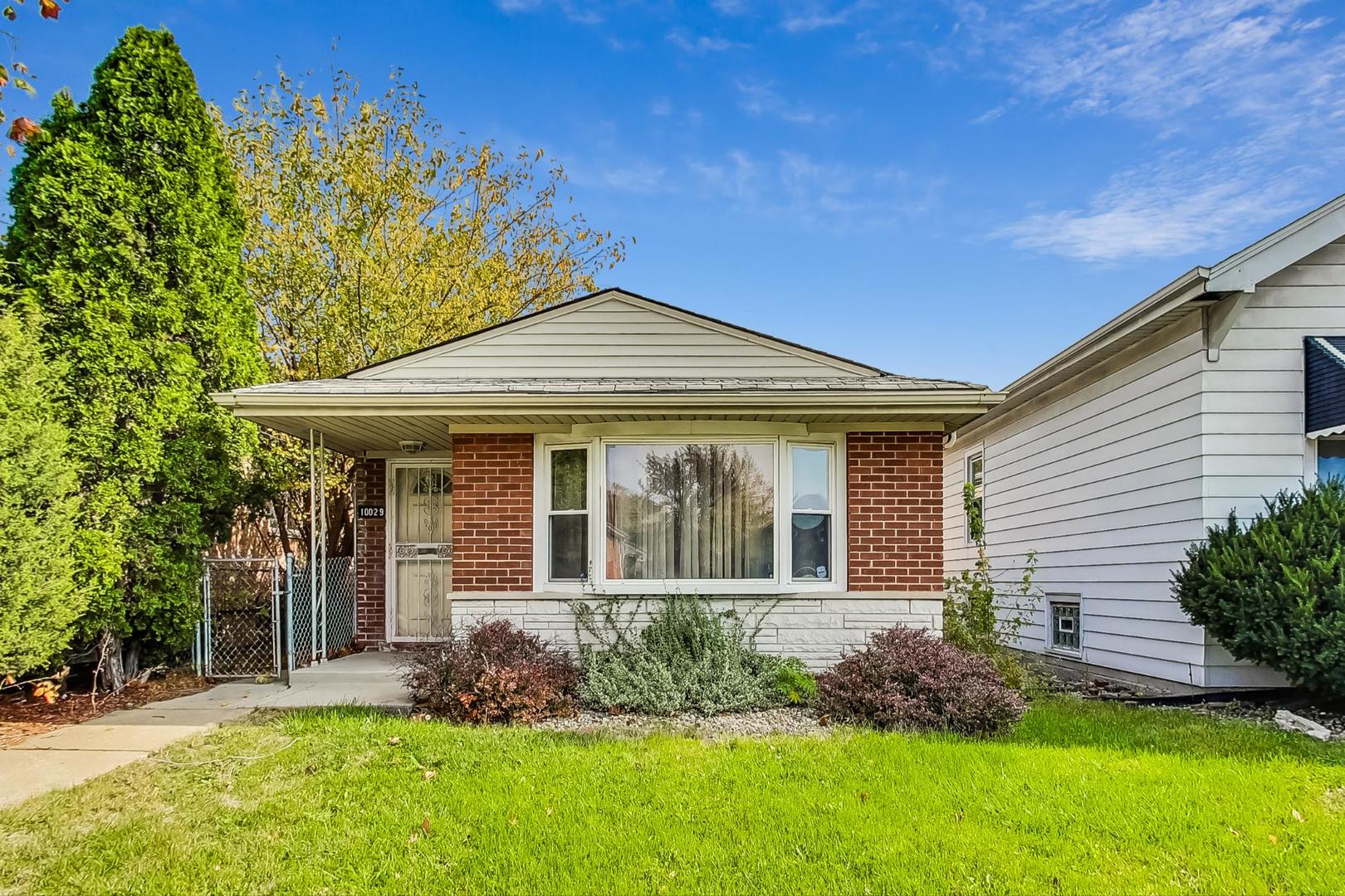 a front view of a house with a yard and potted plants