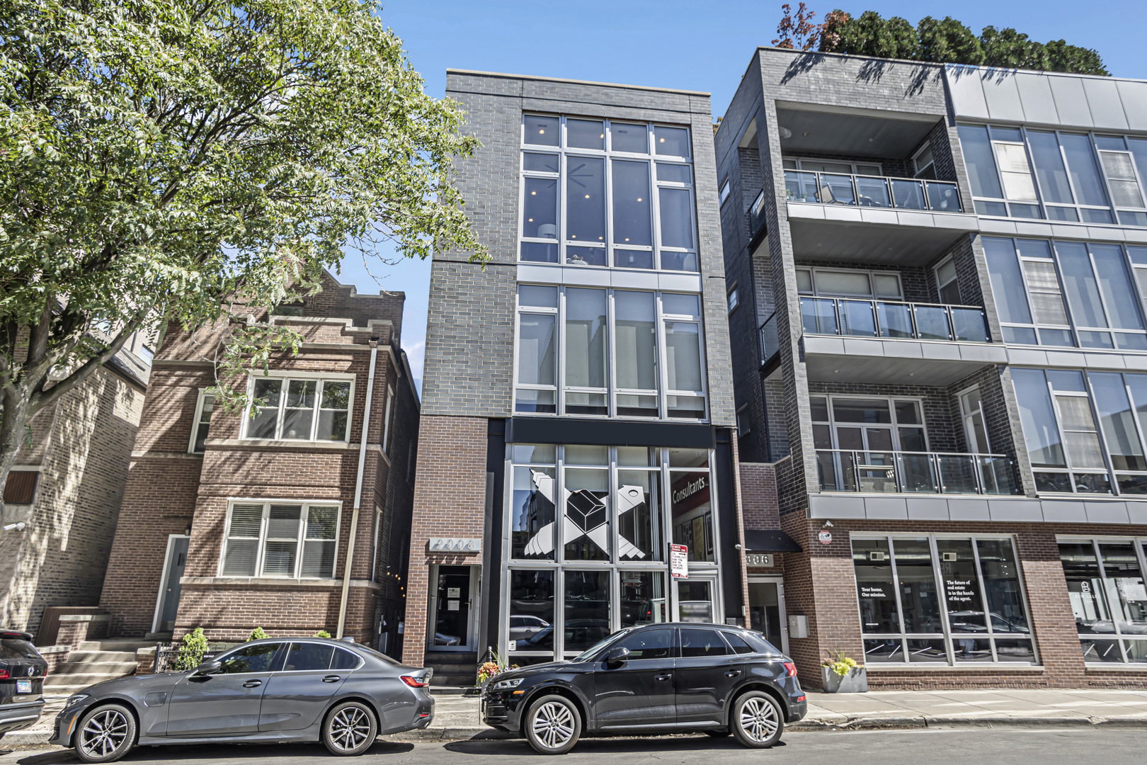 a front view of a residential apartment building with a car parked