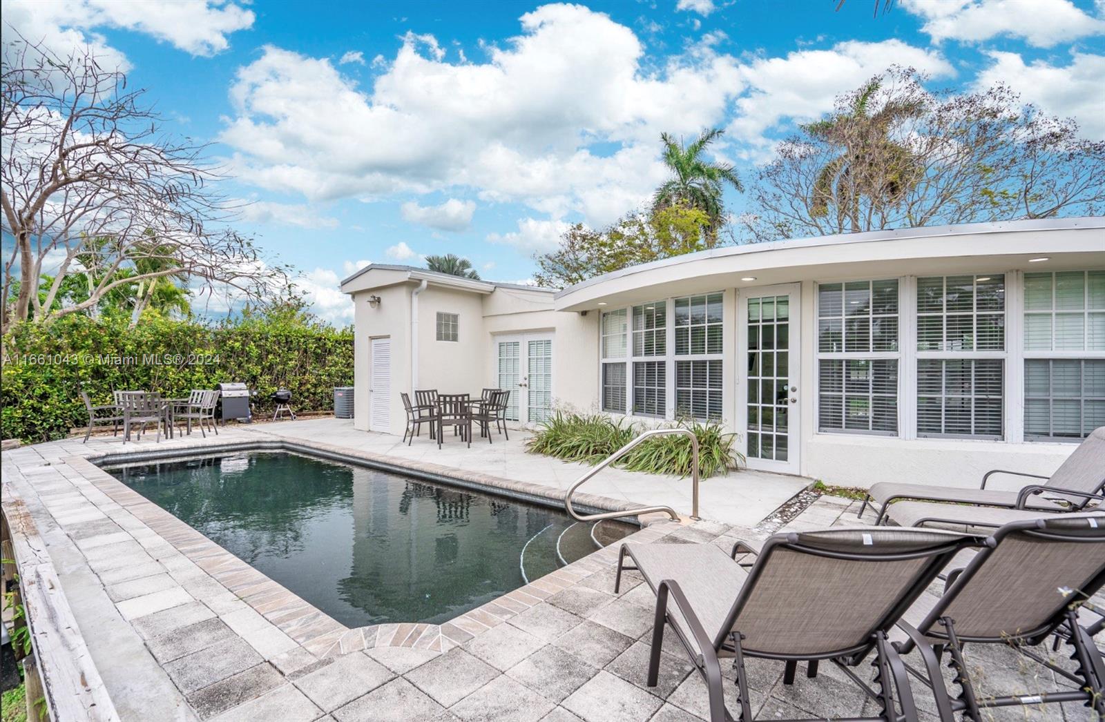 a view of a house with swimming pool and sitting area