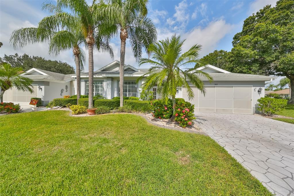 a view of a house with a yard and palm trees