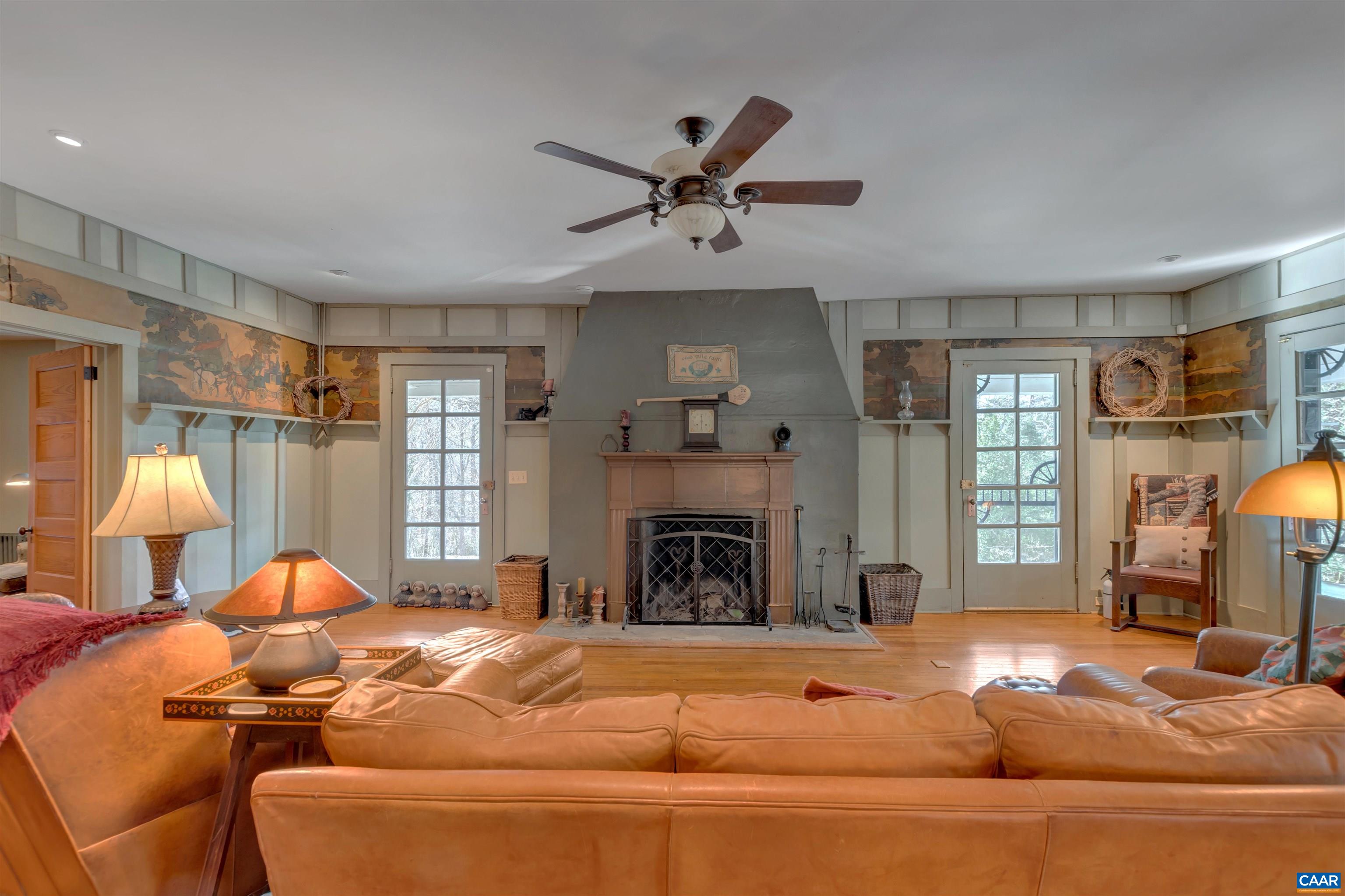 a living room with furniture a fireplace and a chandelier