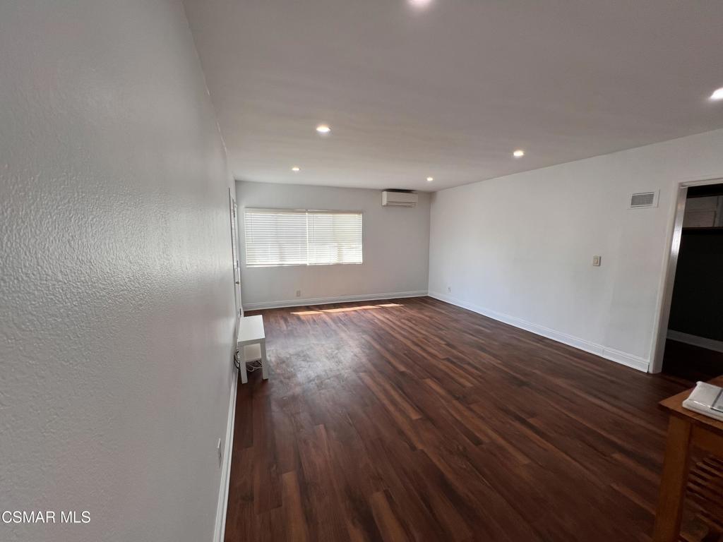 an empty room with wooden floor and sliding door