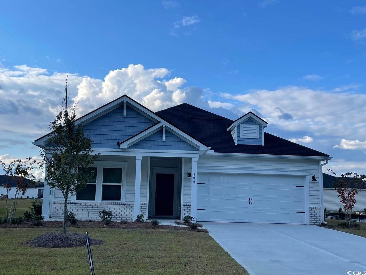 View of front facade with a front yard, a garage,