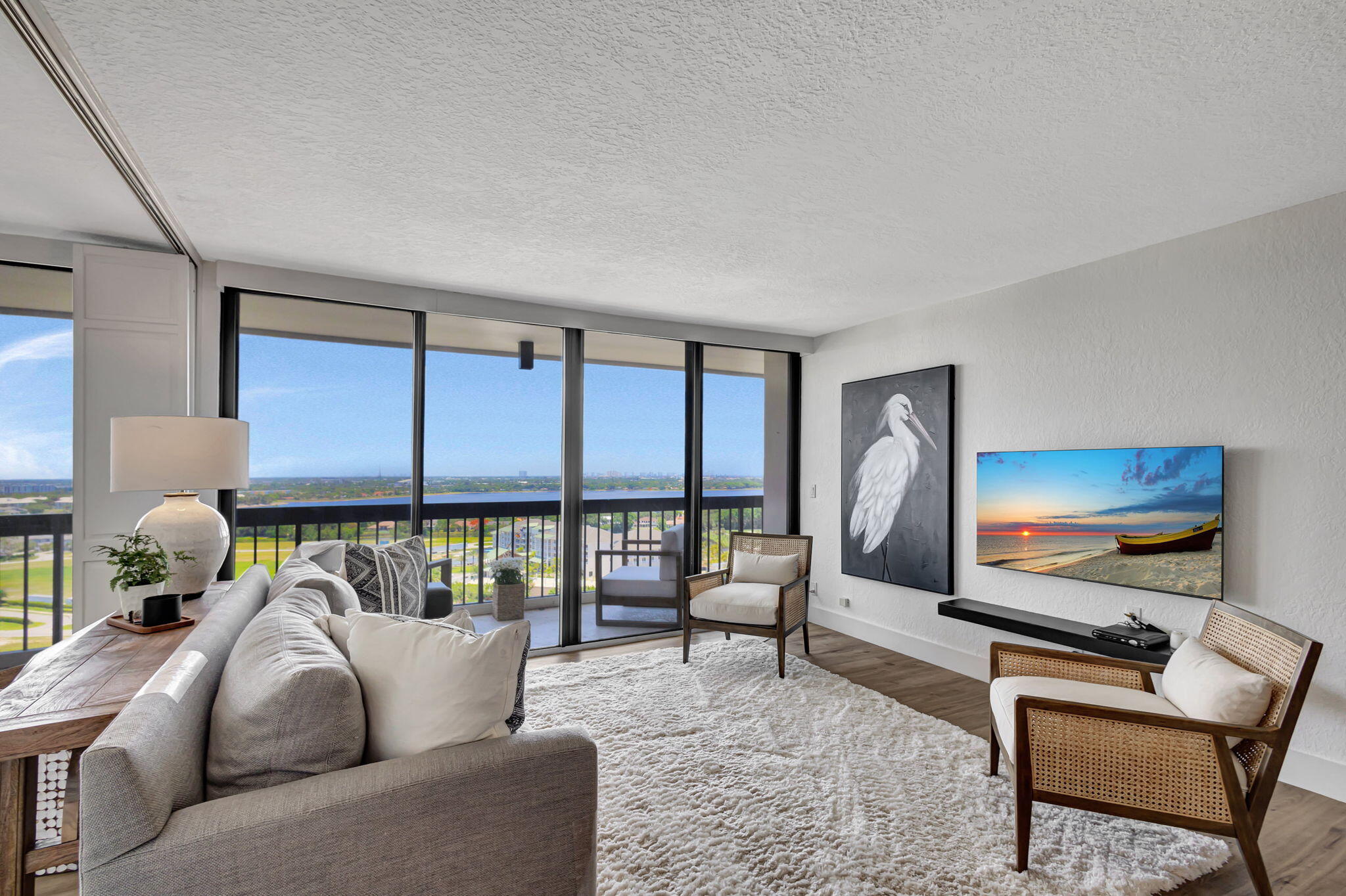 a living room with furniture a flat screen tv and a floor to ceiling window