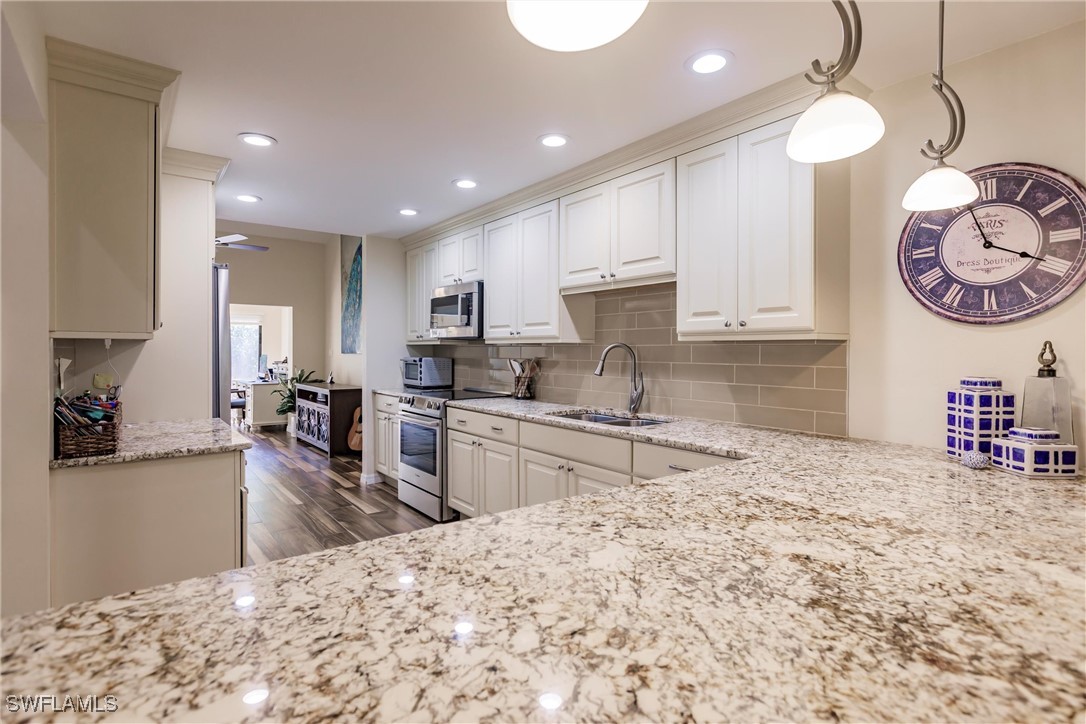 a kitchen with a stove a sink a refrigerator and a fireplace