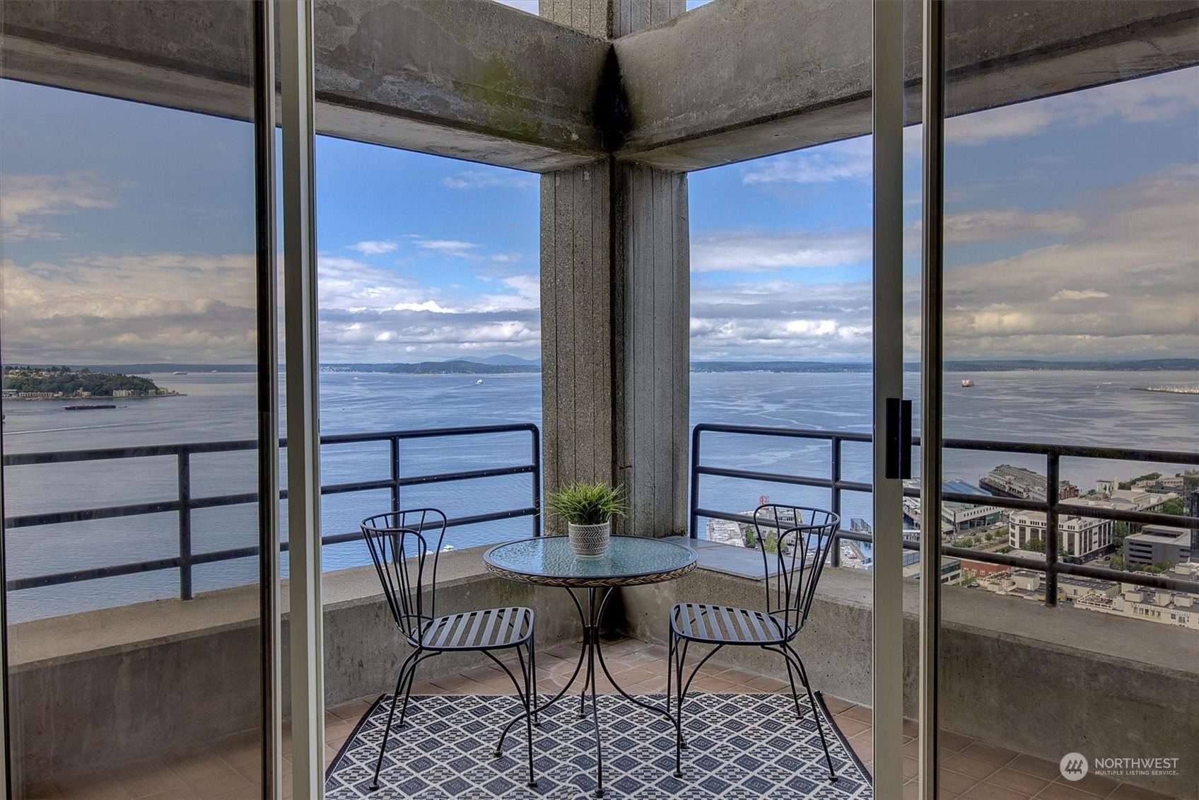 a view of a balcony with chairs and wooden floor