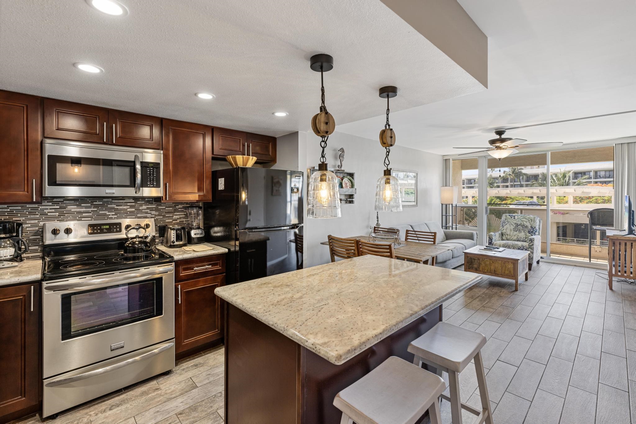 a kitchen with stainless steel appliances a stove a sink a microwave a dining table and chairs