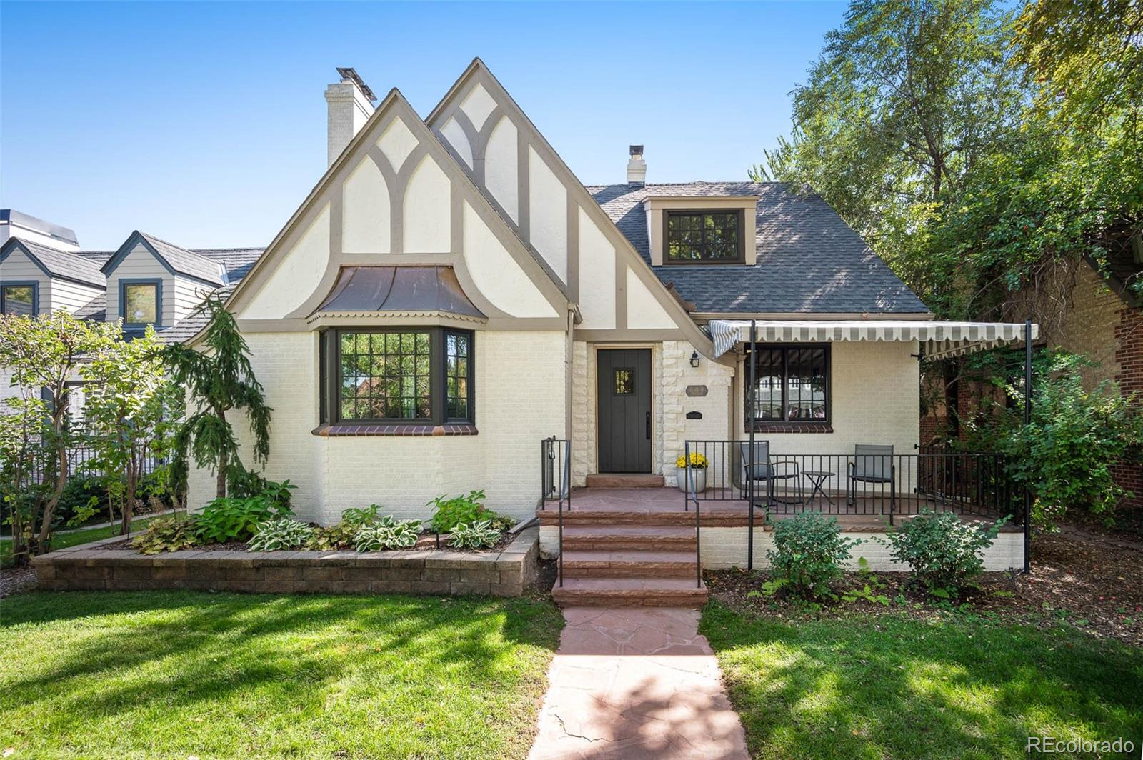 a front view of a house with a yard and a garden