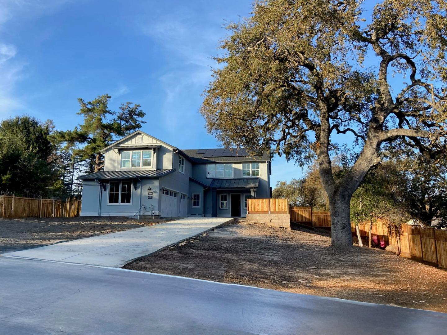 a front view of a house with a tree