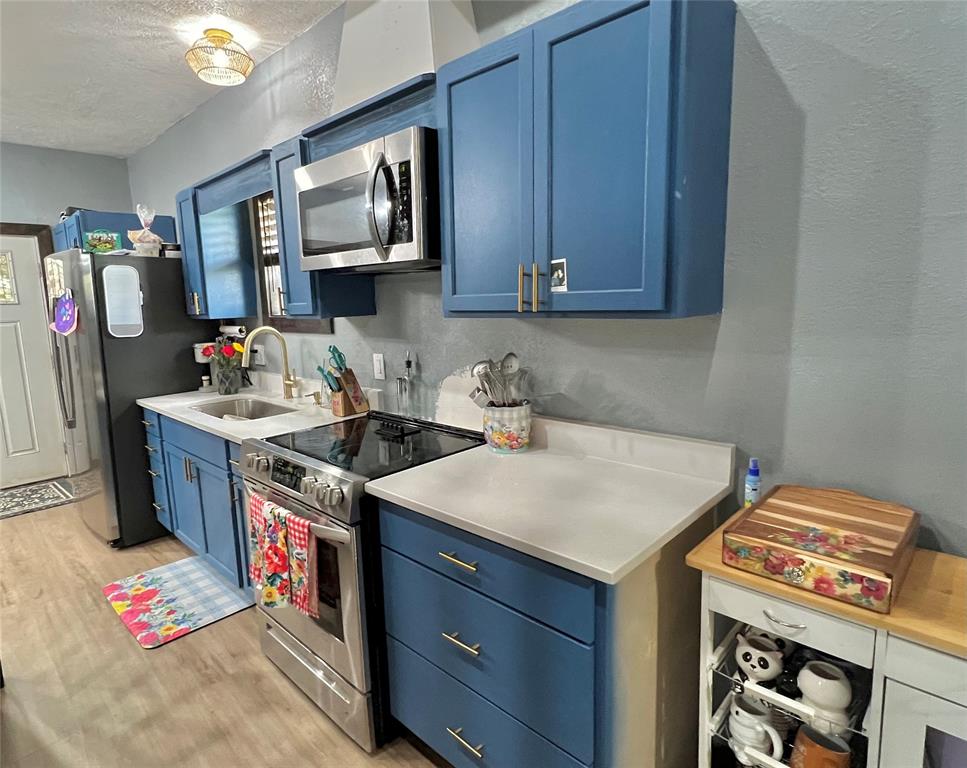 a utility room with stainless steel appliances granite countertop a stove and a sink