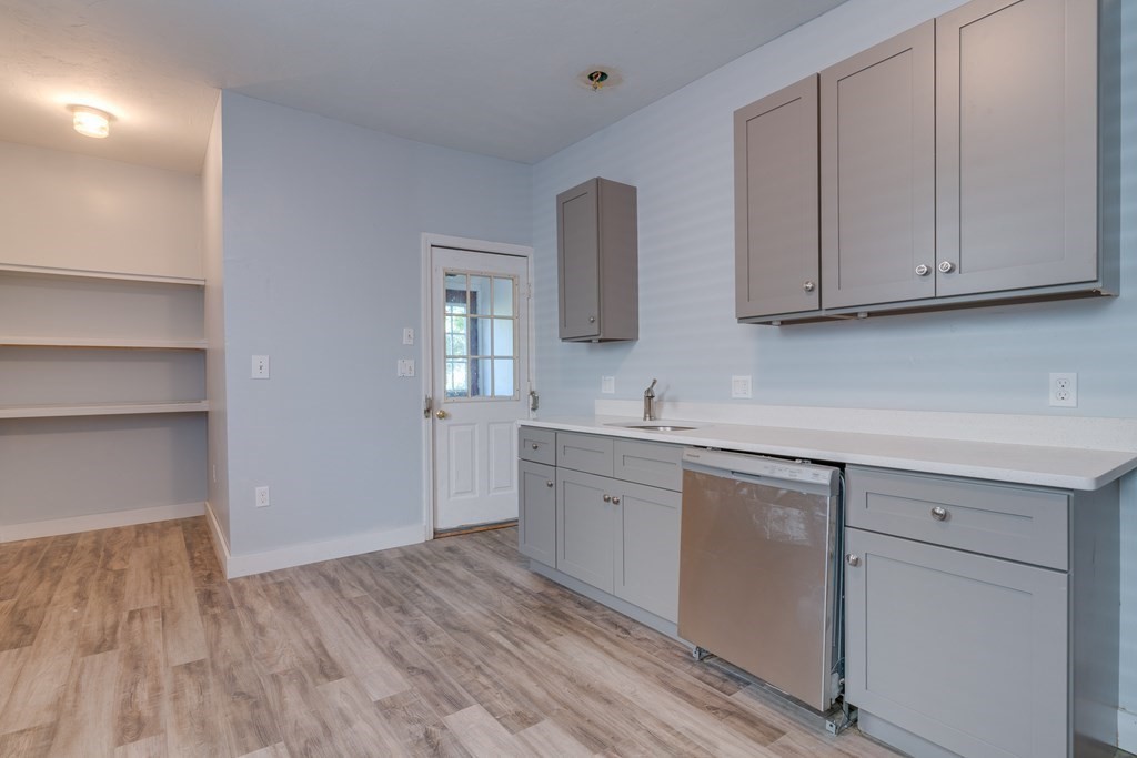 a kitchen with white cabinets and sink