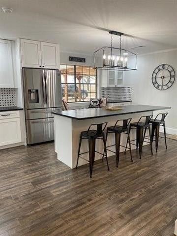 a kitchen with kitchen island granite countertop a table chairs stove and refrigerator