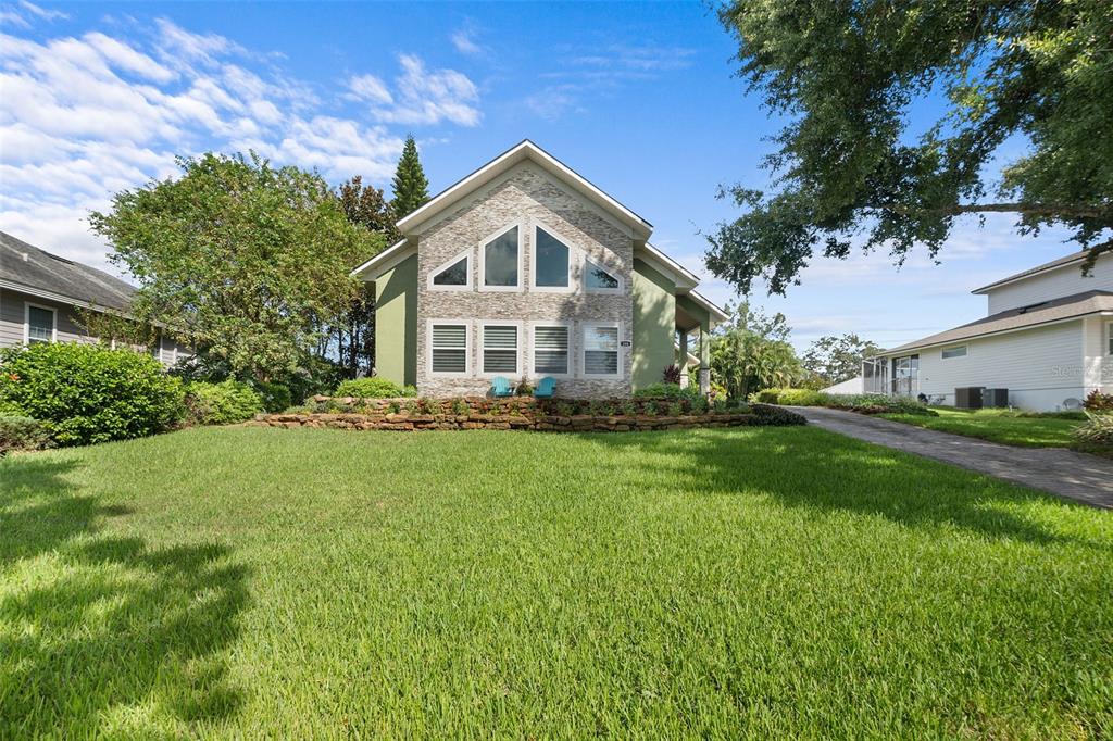 a front view of a house with a yard and trees