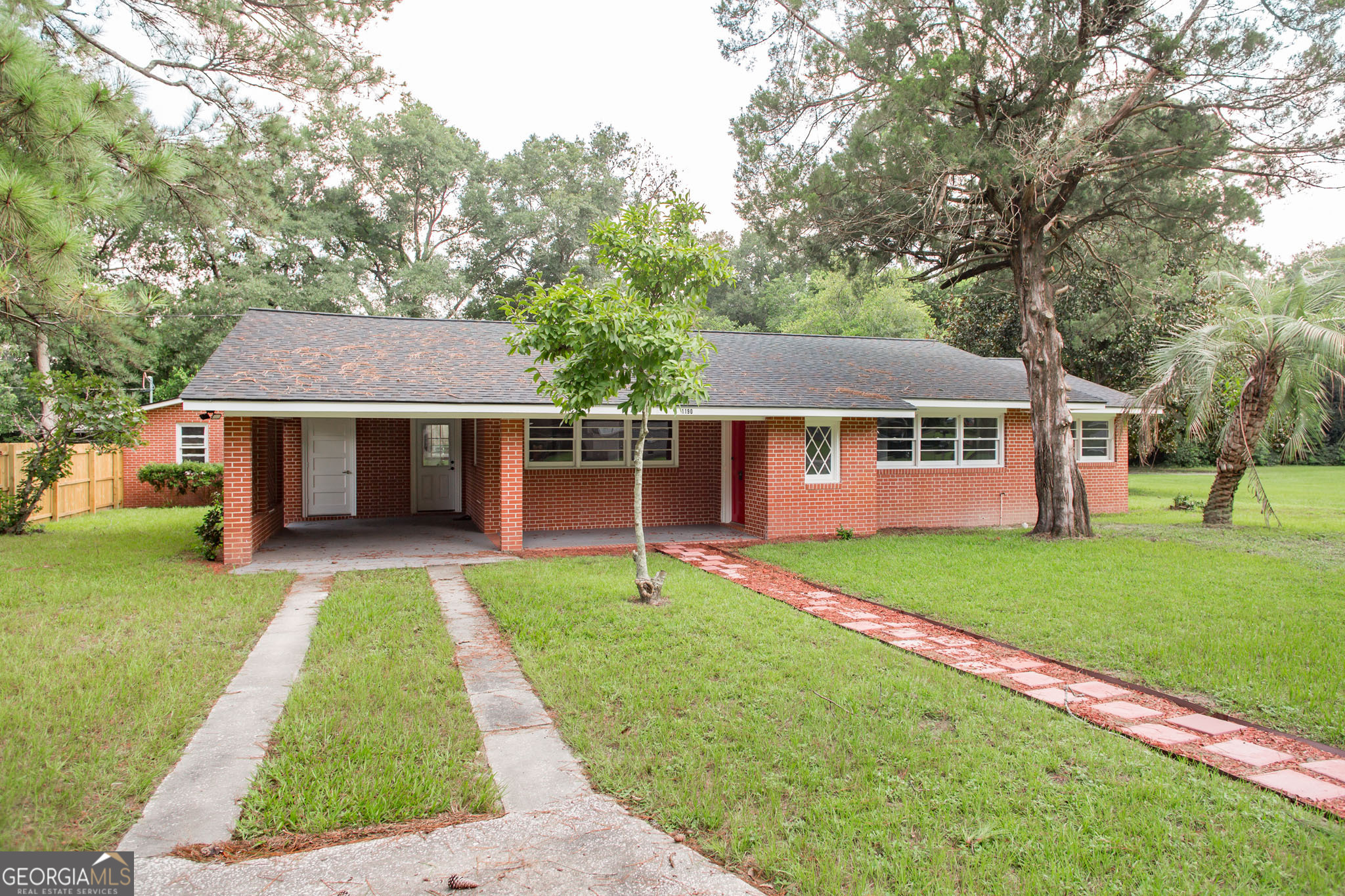 a front view of a house with a yard and trees