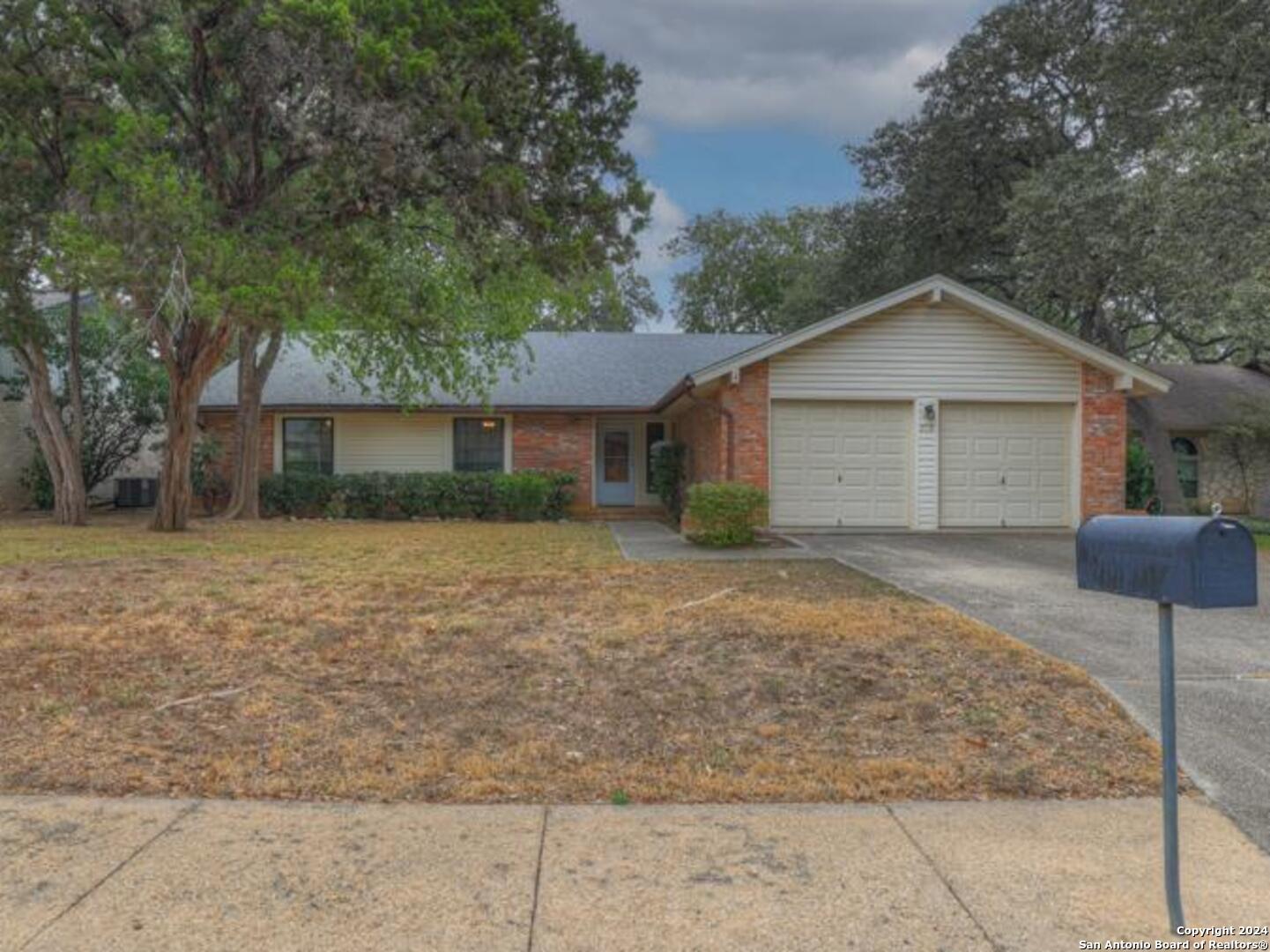 a front view of a house with a yard and trees