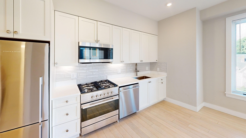 a kitchen with cabinets and steel stainless steel appliances