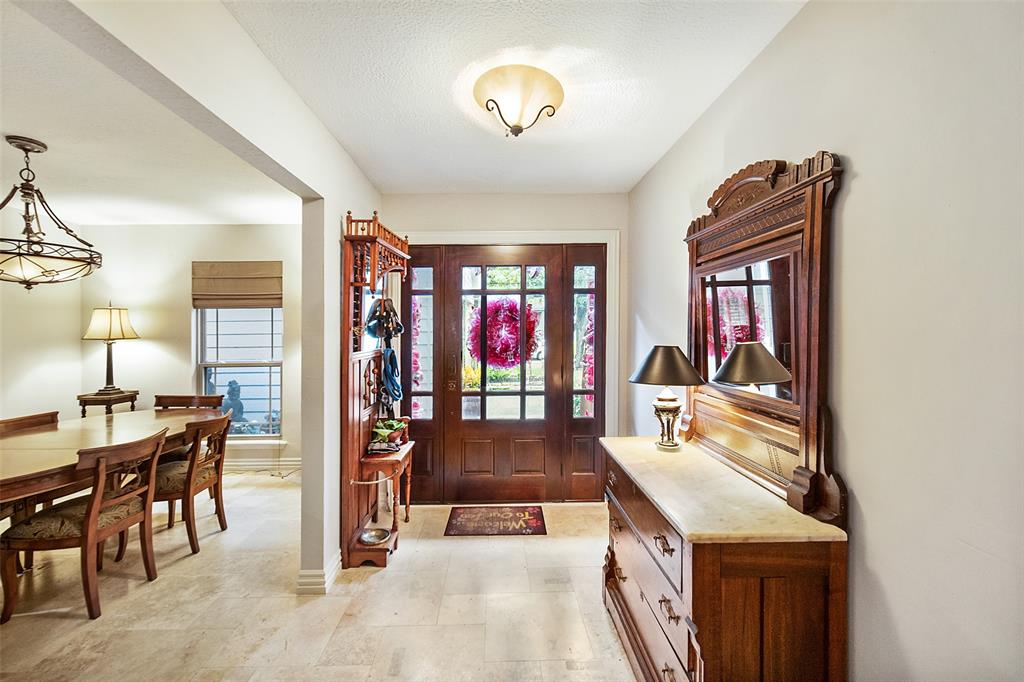 Stepping through the beautiful wood and glass front door, you are welcomed by stunning travertine tile that flows seamlessly throughout the home.