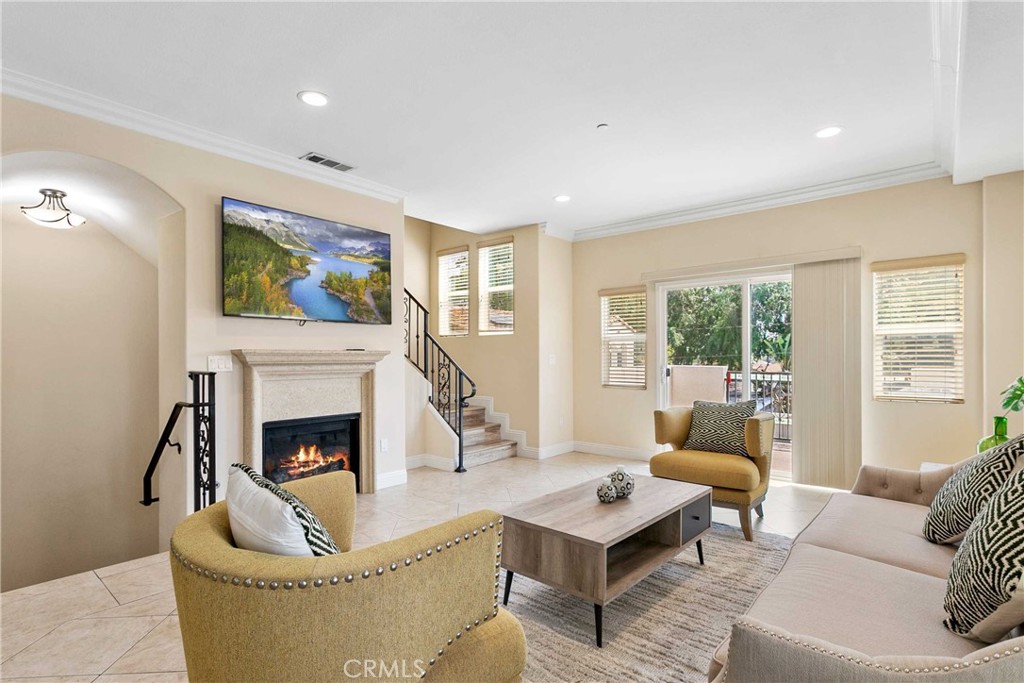 a living room with furniture a flat screen tv and a fireplace