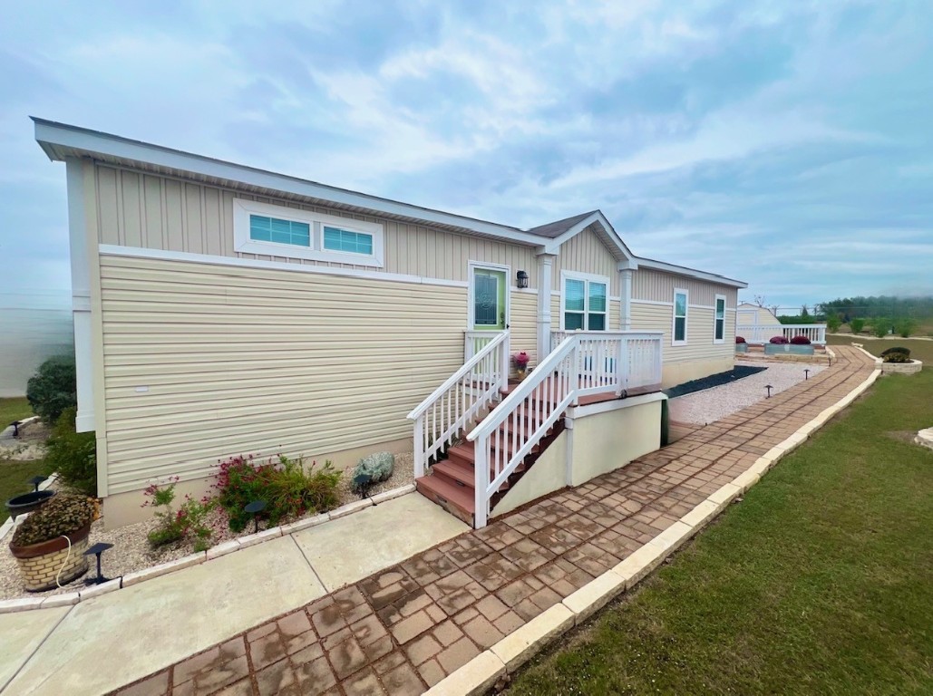 a view of a house with wooden deck and furniture