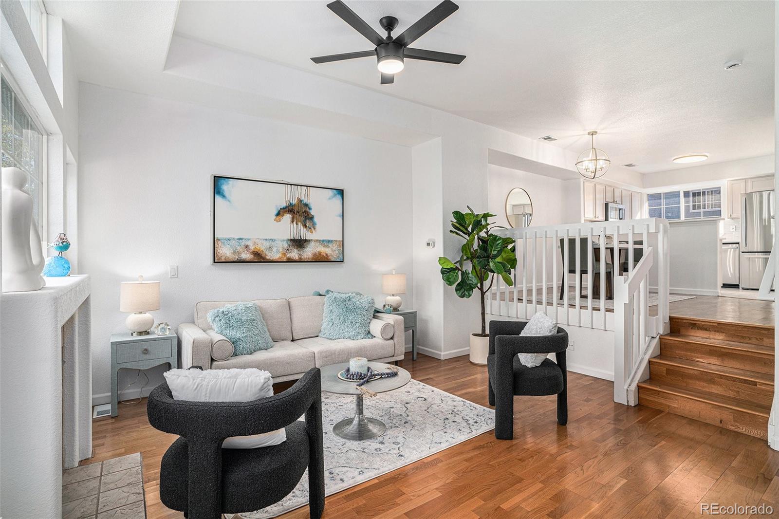 a living room with furniture and a painting on the wall