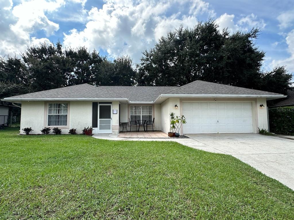 a front view of a house with a garden and trees