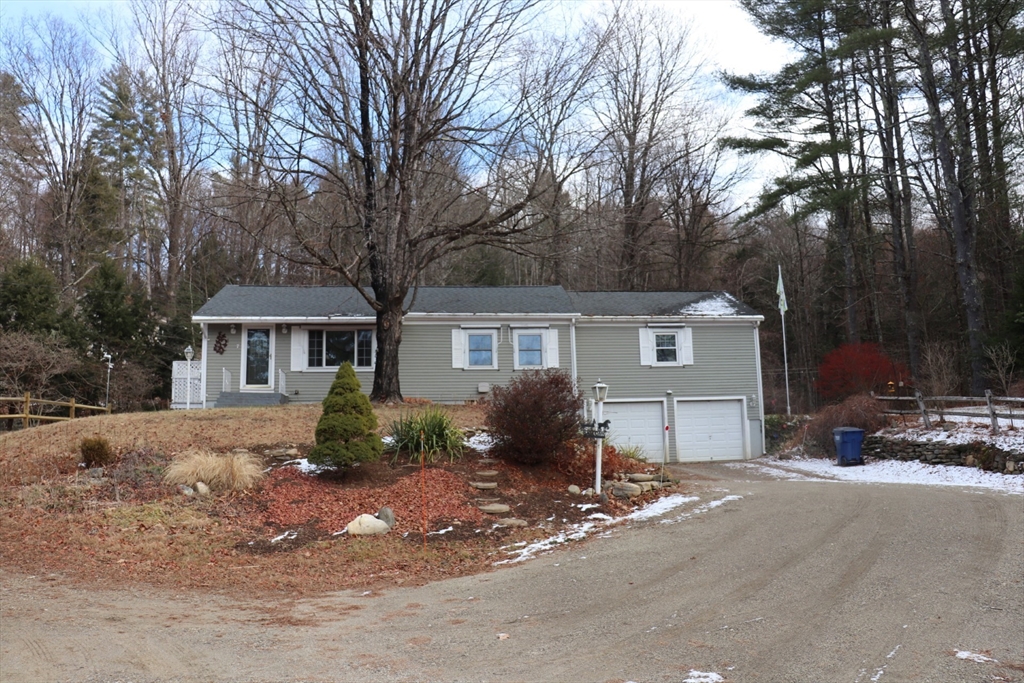 a front view of a house with a yard and trees