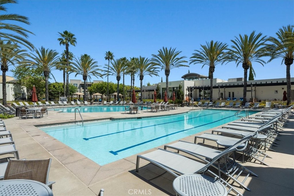 a view of swimming pool with outdoor seating and house in the background