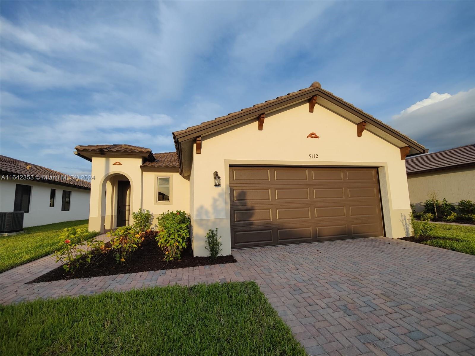 a front view of a house with a yard and garage