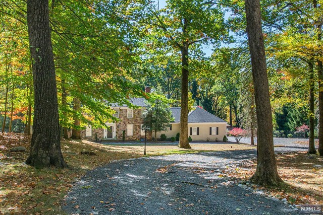 a front view of a house with a yard and large trees