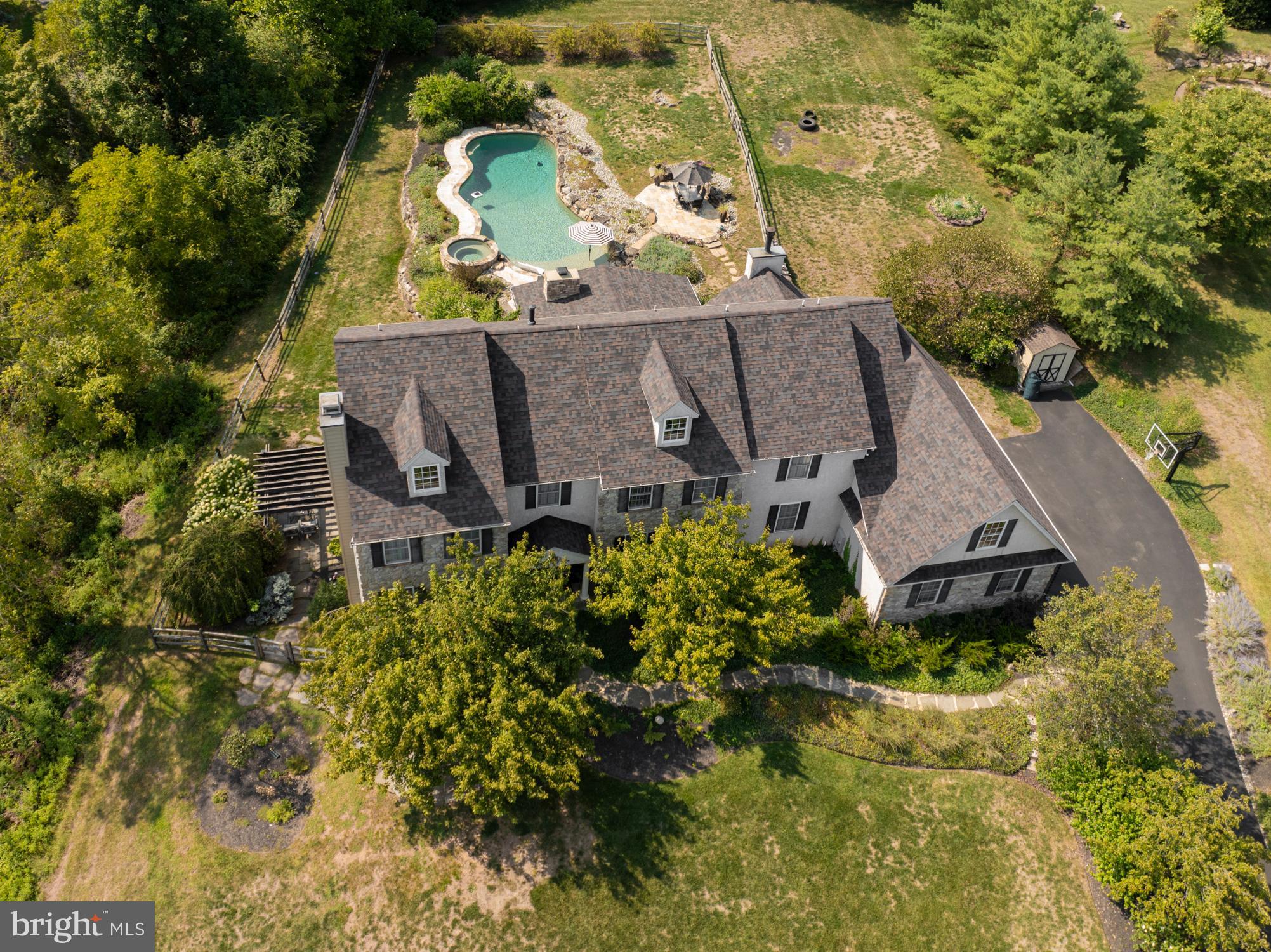 an aerial view of a house with a yard swimming pool and outdoor seating