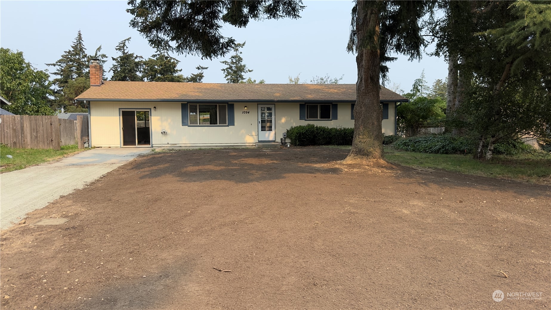 a front view of a house with a garden and trees