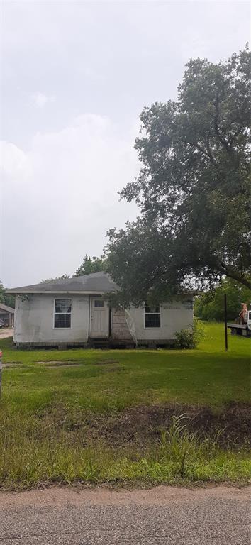 a view of a house with a big yard and large trees