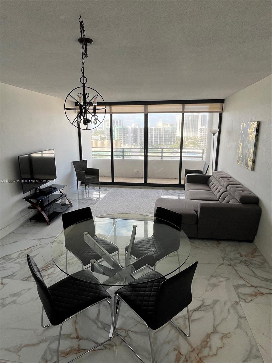 a living room with furniture and floor to ceiling windows