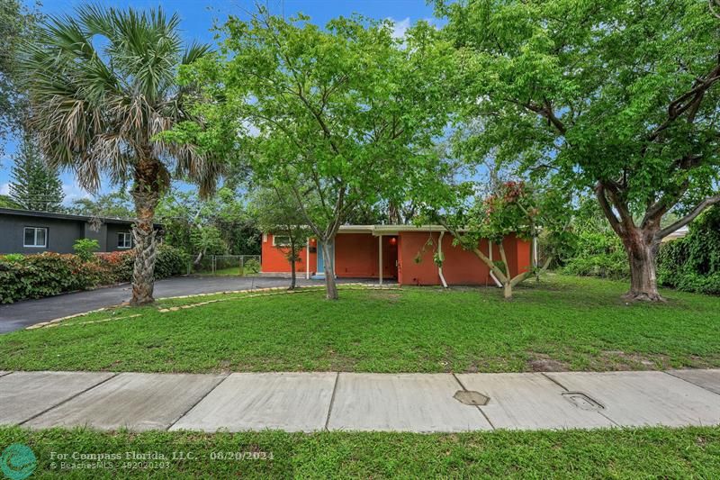 a front view of a house with a yard and trees